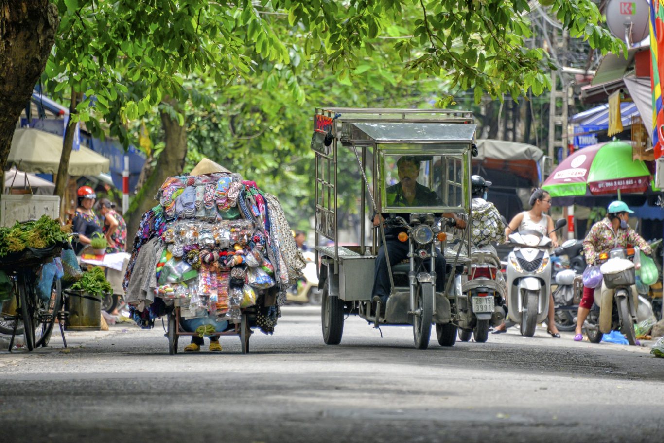 Strassenhändler in Hanoi Straßenhändler und Motorroller im geschäftigen Straßenleben von Hanoi in Vietnam